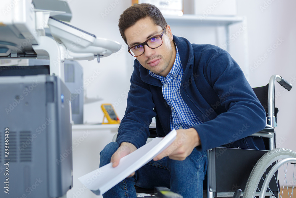 Fototapeta premium businessman in wheelchair using a printer