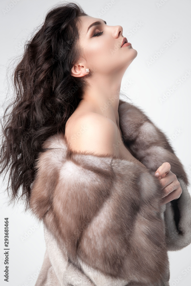 Beautiful elegant woman posing in luxury fashion fur coat over white background. Winter clother. Beautiful elegant woman posing in luxury fashion fur coat over white background. Winter clother.