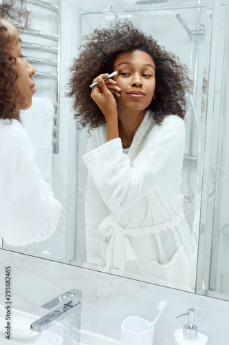 Beauty makeup. Woman applying cosmetics on eyes at bathroom