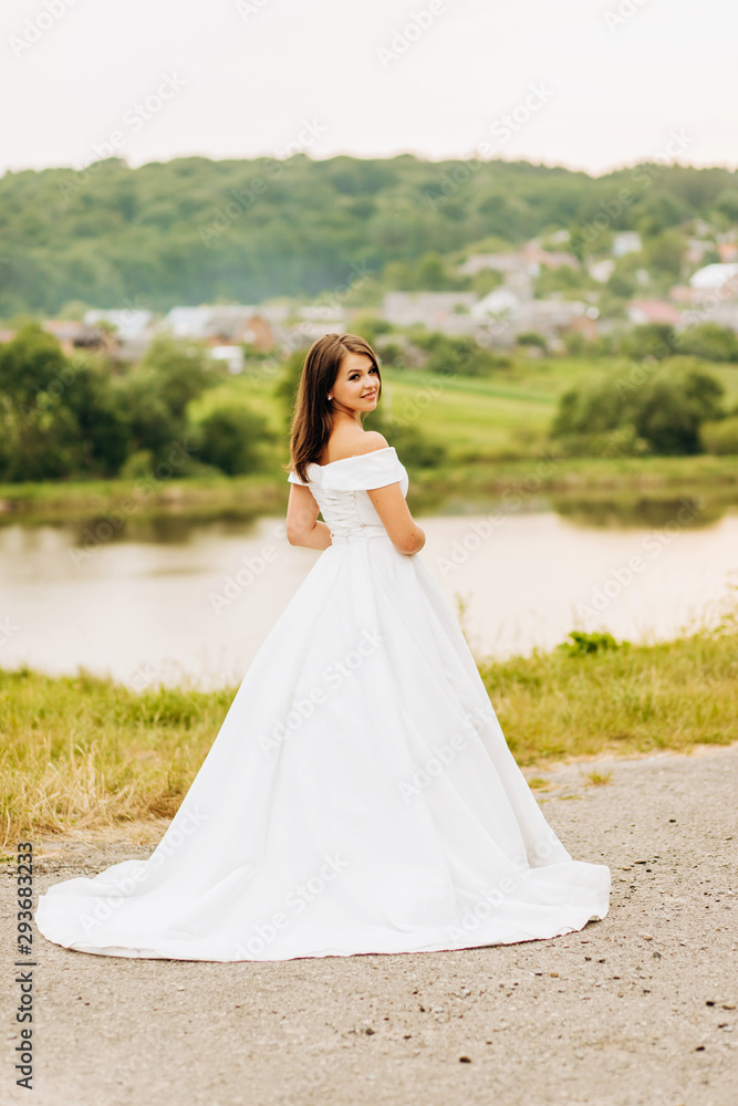 Luxury bride in white dress posing in the park