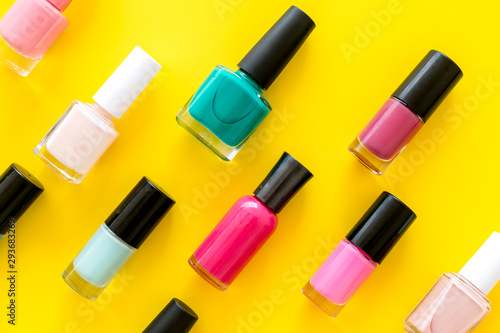 Nail polishes background on yellow table top view pattern