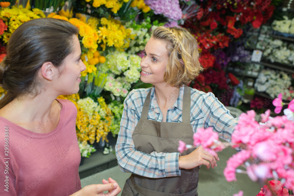beautiful young female customer smiling with florist beautiful young female customer smiling with florist