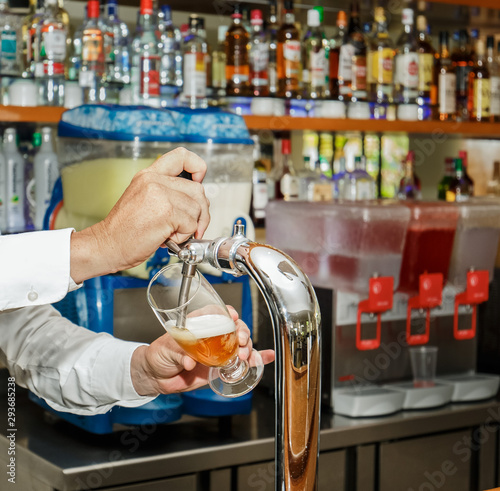 amazing, beautiful closeup view of bartender hands holding a glass and serving beer in the bar, restaurant