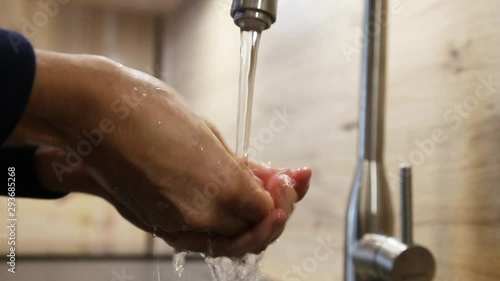 Woman is washing her hands in a newly decorated modern kitchen photo