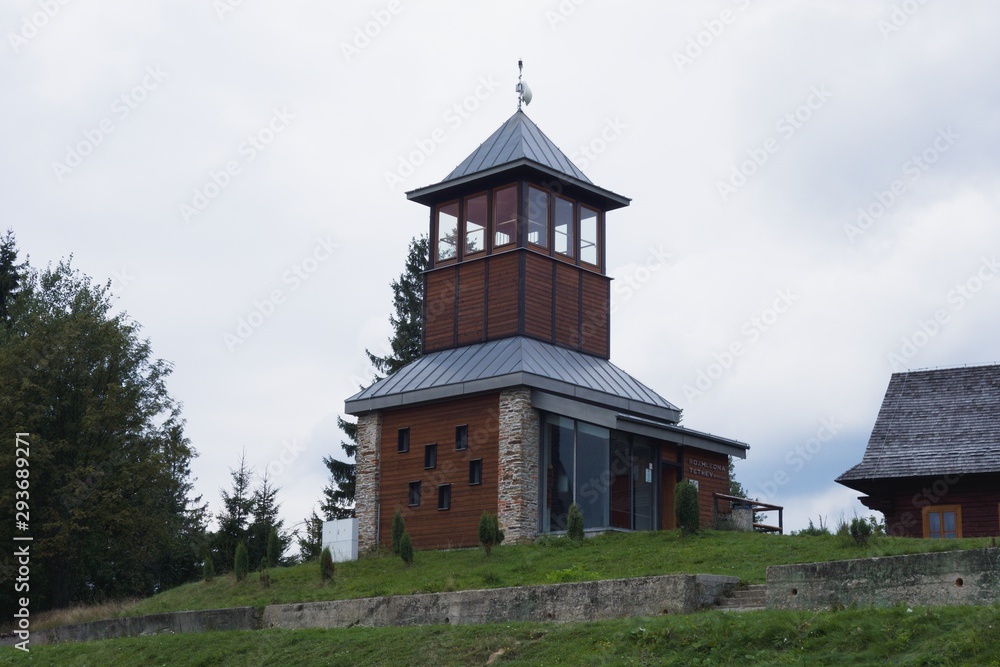 Tetrev (grouse) wooden lookout tower on the elevation of Cerchlany Beskyd, Moravian-Silesian Beskydy Mountains. Modern architectonic style. Summer day.