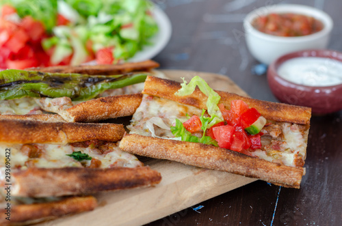 Turkish Pita(pide) with minced meat and cheese and souces.