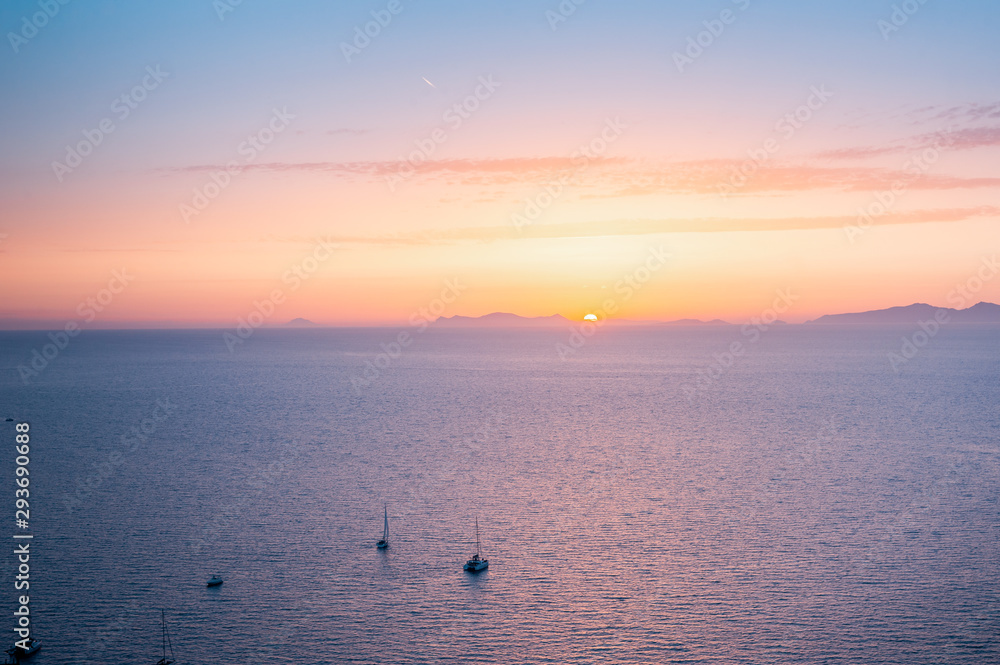 Amazing evening view of Fira, caldera, volcano of Santorini, Greece with cruise ships at sunset. Cloudy dramatic sky