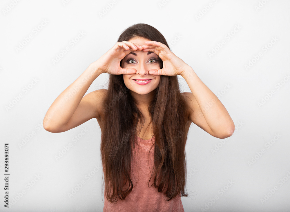 Beautiful funny woman showing the control sign holding hands near the eyes with big eyes on blue background. Binoculars gesture. Beautiful funny woman showing the control sign holding hands near the eyes with big eyes on blue background. Binoculars gesture.