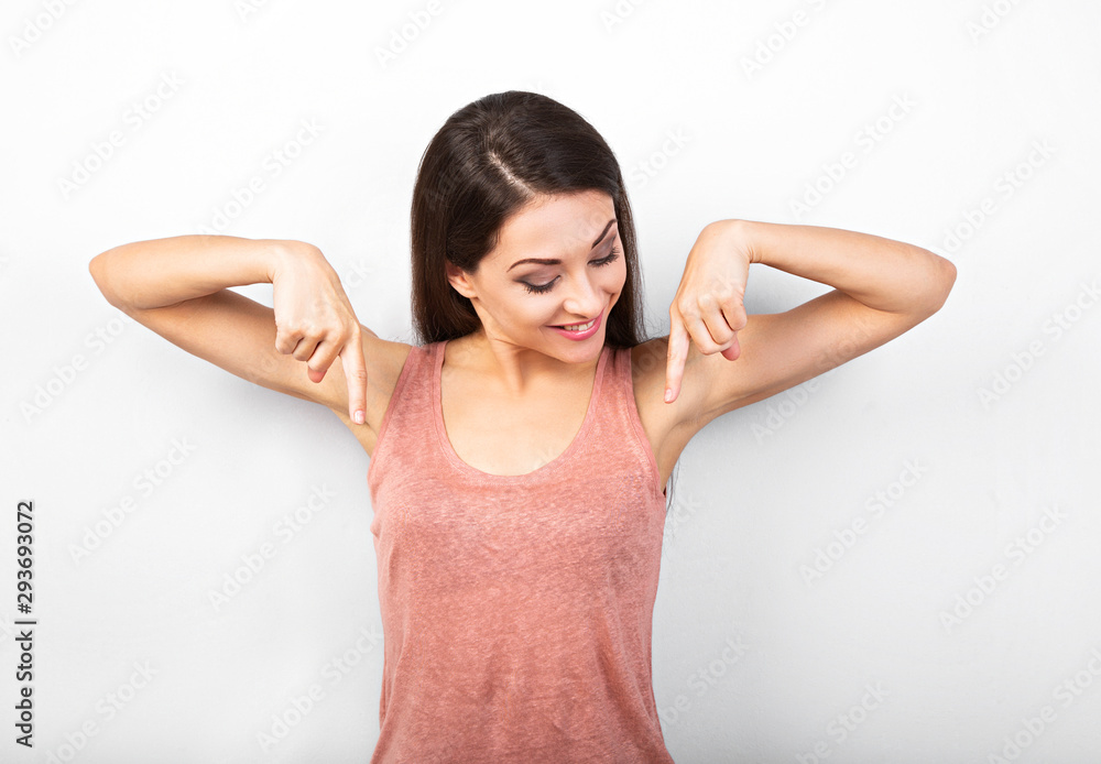 Beautiful positive makep woman in pink casual shirt showing two fingers down on blue copy space background. Closeup Beautiful positive makep woman in pink casual shirt showing two fingers down on blue copy space background. Closeup
