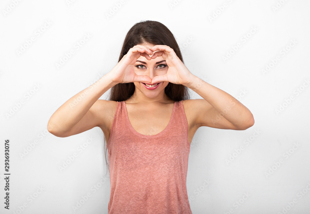 Beautiful sporty healthy woman in love showing the heart by two hands with enjoying smiling face and thinking about happiness. Beautiful sporty healthy woman in love showing the heart by two hands with enjoying smiling face and thinking about happiness.