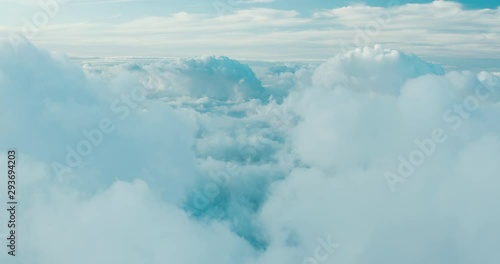 Aerial view flying in the sky above blue and white clouds