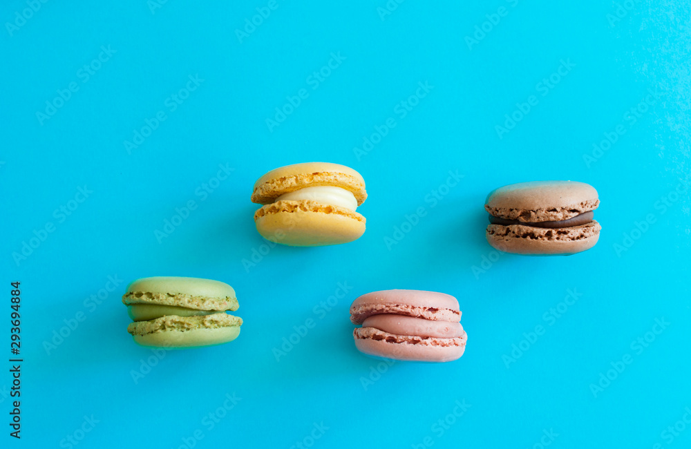 Top view of a colorful french macaron dessert on a blue background Top view of a colorful french macaron dessert on a blue background