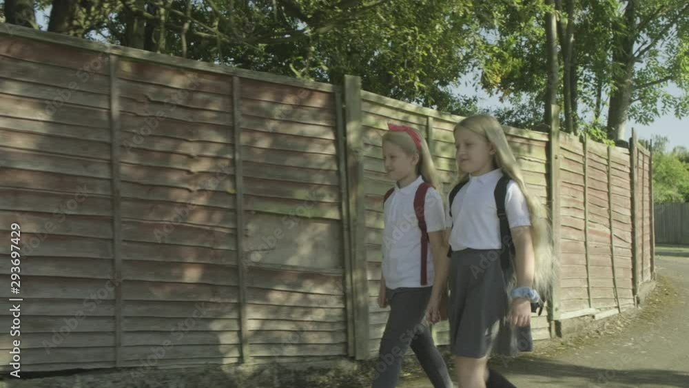 Pre teen twin caucasian girls walking to school Pre teen twin caucasian girls walking to school