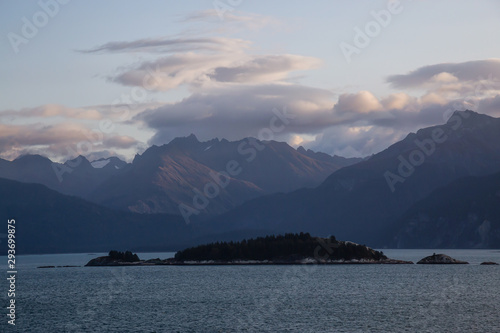 Beautiful Panoramic View of American Mountain Landscape on the Ocean Coast during a cloudy and colorful sunrise in fall season. Taken in Glacier Bay National Park and Preserve, Alaska, USA.