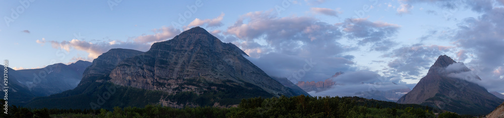Beautiful Panoramic View of American Rocky Mountain Landscape during a Cloudy Morning Sunrise. Taken in Glacier National Park, Montana, United States.
