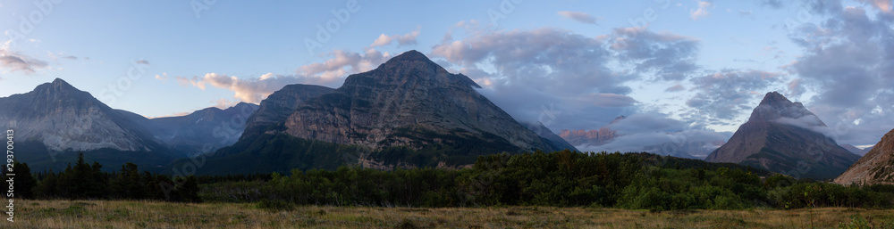 Beautiful Panoramic View of American Rocky Mountain Landscape during a Cloudy Morning Sunrise. Taken in Glacier National Park, Montana, United States.