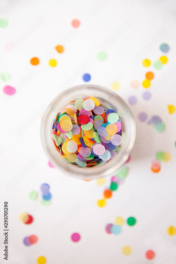 Colorful Confetti in a jar on a white background.