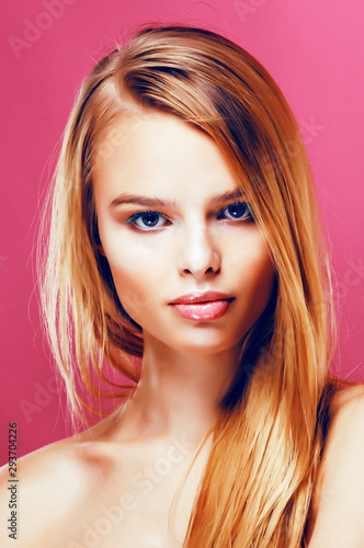 young pretty blonde real woman with hairstyle close up and makeup on pink background smiling, stylish fashion look like baby doll