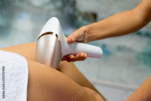 Woman having her leg hair removed by female beautician. Laser epilation treatment. photo