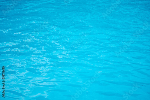 urface of blue swimming pool,background of water in swimming pool © chongsiri