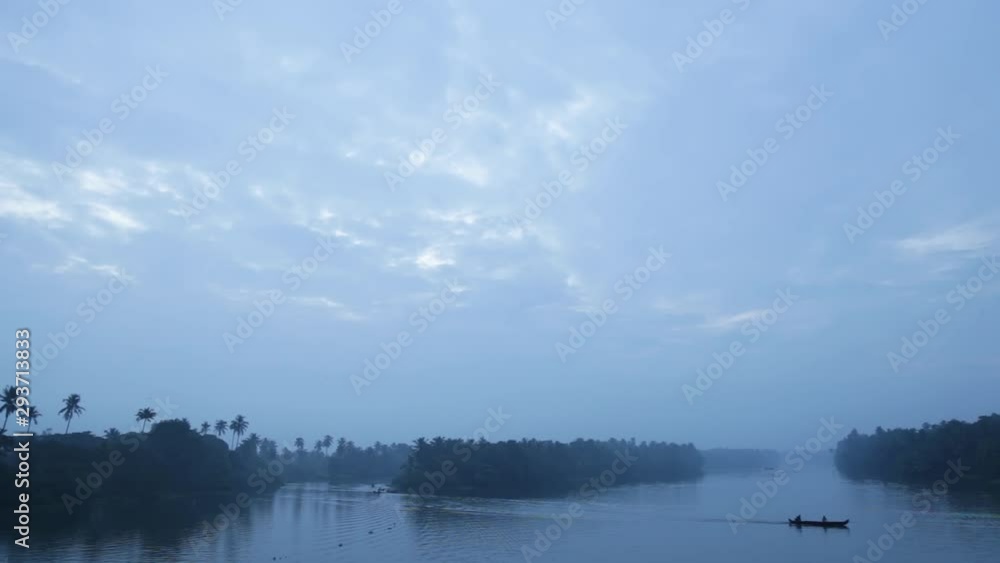 Sunrise in backwaters,fishermen arriving shore Sunrise in backwaters,fishermen arriving shore