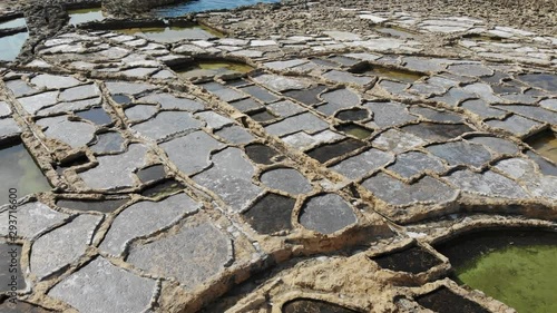 A slow, low-level aerial drone shot skims across the Salt Pans of Gozo island in Malta. photo