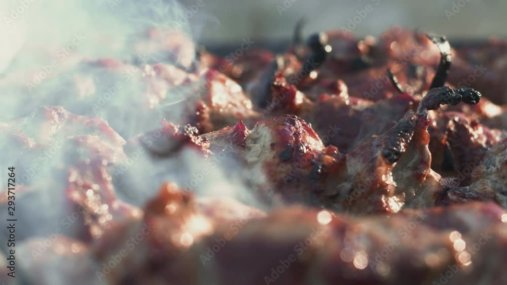 Closeup smoking meat on barbecue grill outdoor. Smoked bbq grilling over grill Closeup smoking meat on barbecue grill outdoor. Smoked bbq grilling over grill