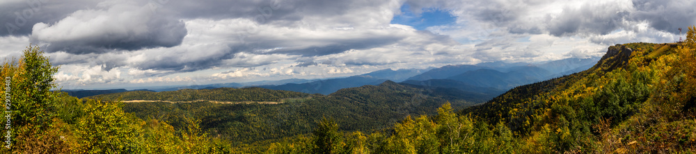 Panoramic views of the mountains and yellow-orange trees in autumn. The Caucasus strict nature reserve in Russia
