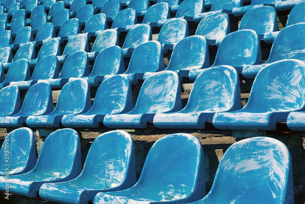Many old blue chairs in a football stadium, for visitors needing replacement or reconstruction Many old blue chairs in a football stadium, for visitors needing replacement or reconstruction