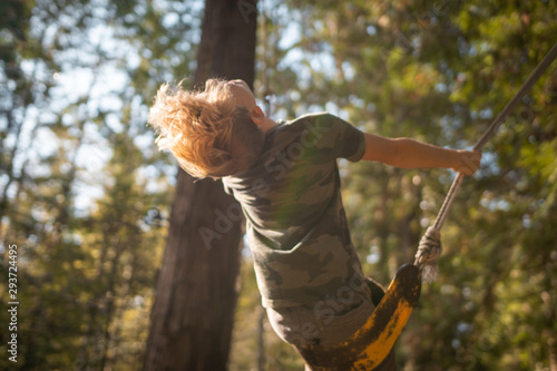 boy on a swing in the forest