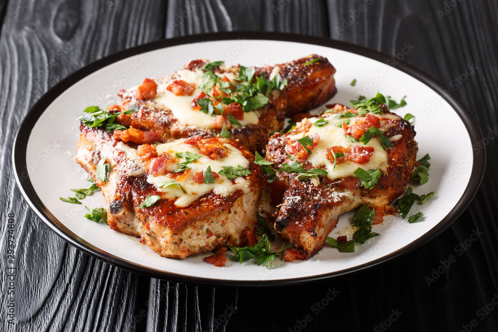 Festive menu fried pork chops with melted cheese and bacon closeup on a plate. horizontal