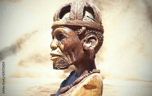 African art. Close up of African traditional wooden Statue figurine on a fur background photo