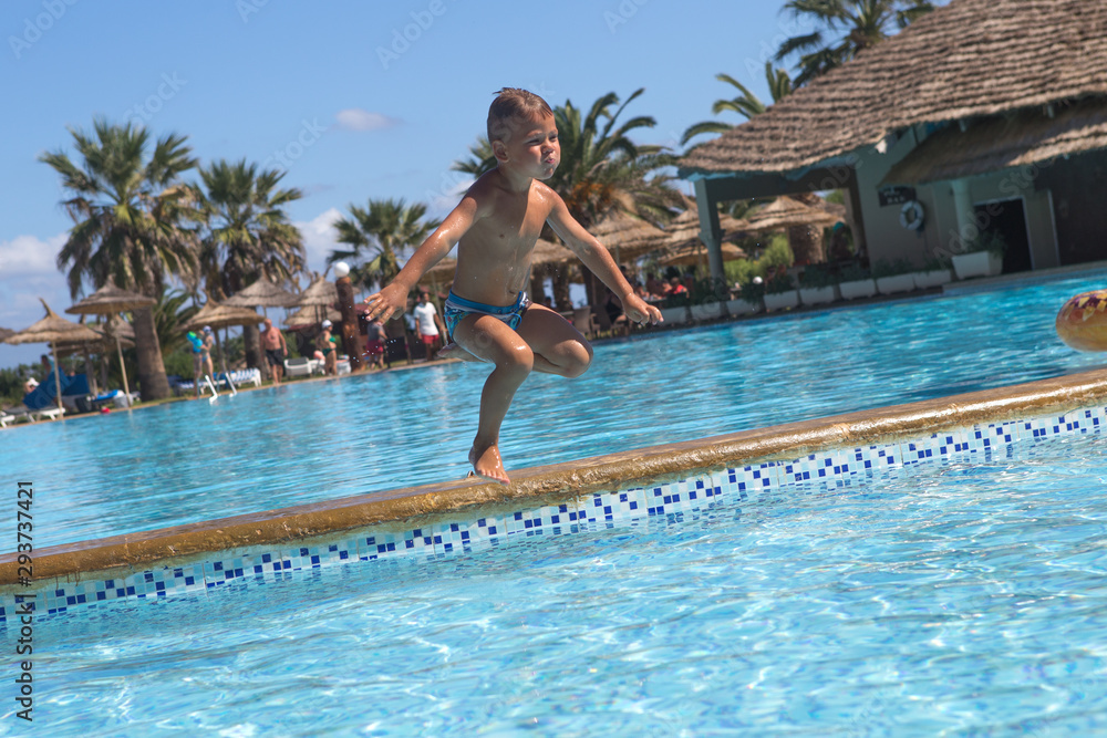  Boy having fun making fantastic jump into swimming pool.