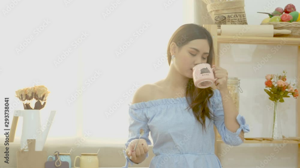 4K. beautiful Asian woman enjoy drinking coffee in the morning with smiley face near the window with morning sunlight 4K. beautiful Asian woman enjoy drinking coffee in the morning with smiley face near the window with morning sunlight