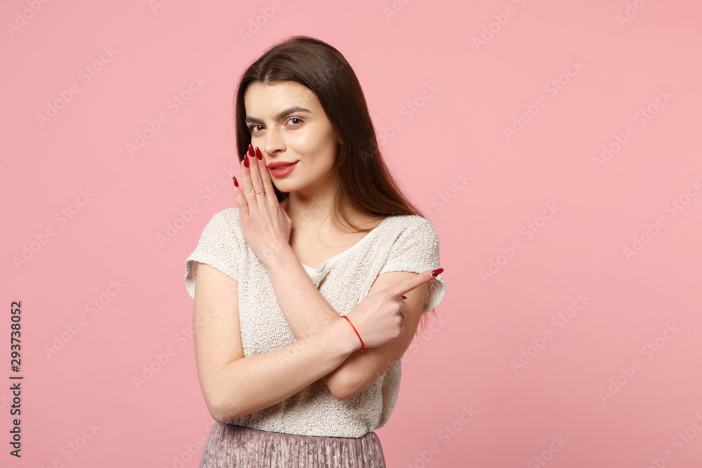 Young woman in casual light clothes posing isolated on pastel pink background. People lifestyle concept. Mock up copy space. Whispers gossip tells secret with hand gesture pointing index finger aside. Young woman in casual light clothes posing isolated on pastel pink background. People lifestyle concept. Mock up copy space. Whispers gossip tells secret with hand gesture pointing index finger aside.
