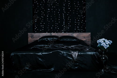bed with black linen in a room with blue light photo