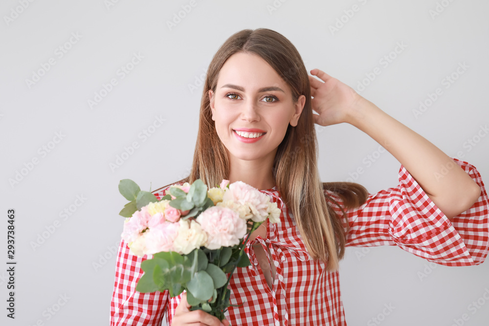 Beautiful young woman with bouquet of carnation flowers on light background Beautiful young woman with bouquet of carnation flowers on light background