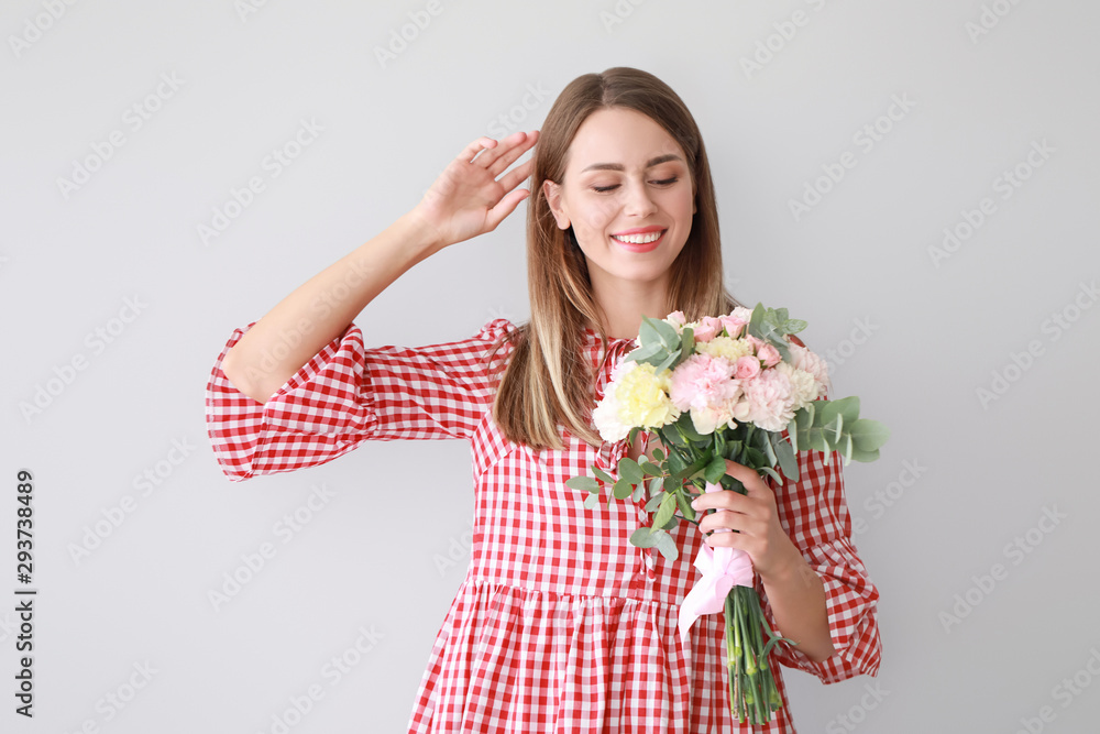 Beautiful young woman with bouquet of carnation flowers on light background Beautiful young woman with bouquet of carnation flowers on light background