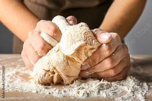 Woman kneading flour in kitchen, closeup