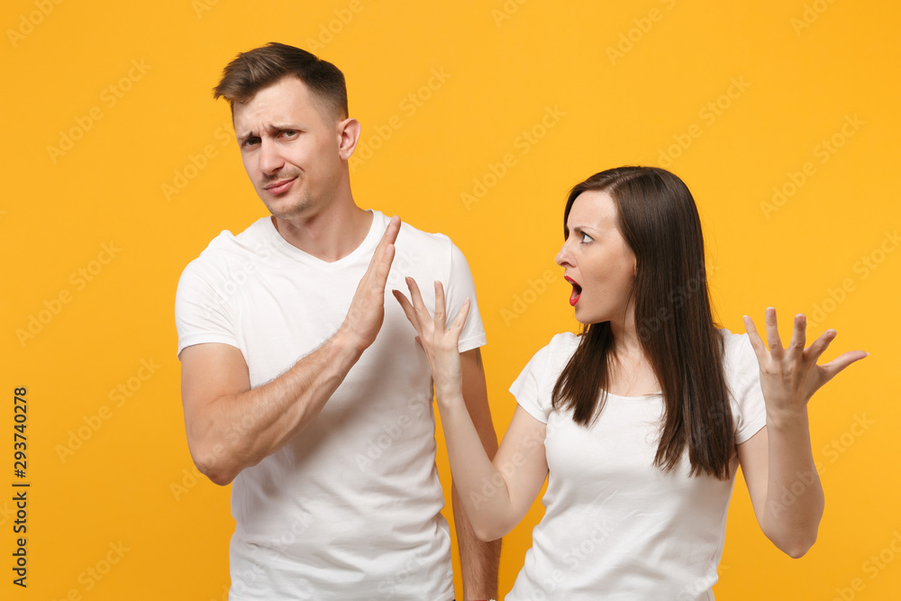 Φωτογραφία Young couple two friends guy girl in white empty blank design t-shirts posing isolated on yellow orange background in studio