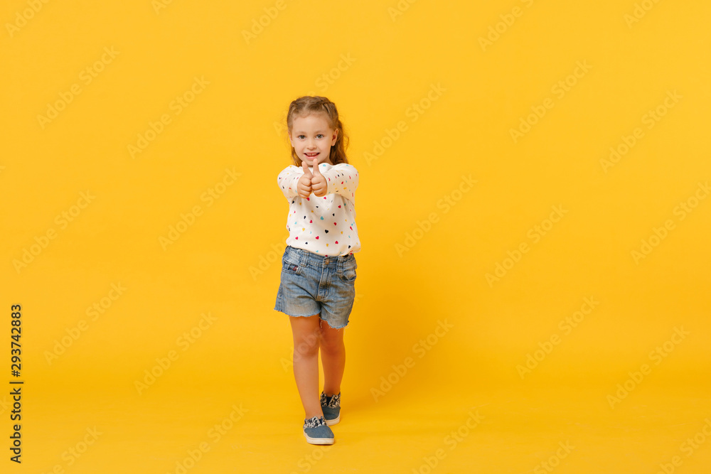 Little cute child kid baby girl 4-5 years old wearing light denim clothes isolated on pastel yellow wall background, children studio portrait. Mother's Day, love family, parenthood childhood concept. Little cute child kid baby girl 4-5 years old wearing light denim clothes isolated on pastel yellow wall background, children studio portrait. Mother's Day, love family, parenthood childhood concept.