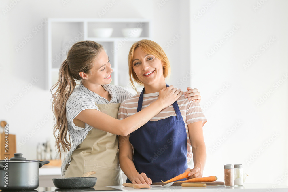 Young woman and her mother cooking together in kitchen Young woman and her mother cooking together in kitchen