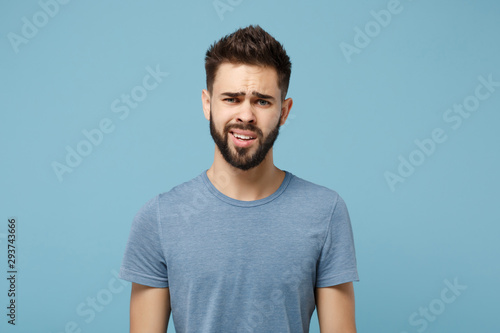 Young perplexed disgusted irritated man in casual clothes posing isolated on blue wall background, studio portrait. People sincere emotions lifestyle concept. Mock up copy space. Looking camera. photo