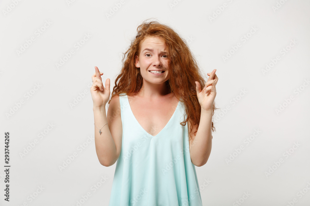 Young redhead woman girl in casual light clothes posing isolated on white background. People lifestyle concept. Mock up copy space. Waiting for special moment, keeping fingers crossed, making wish.