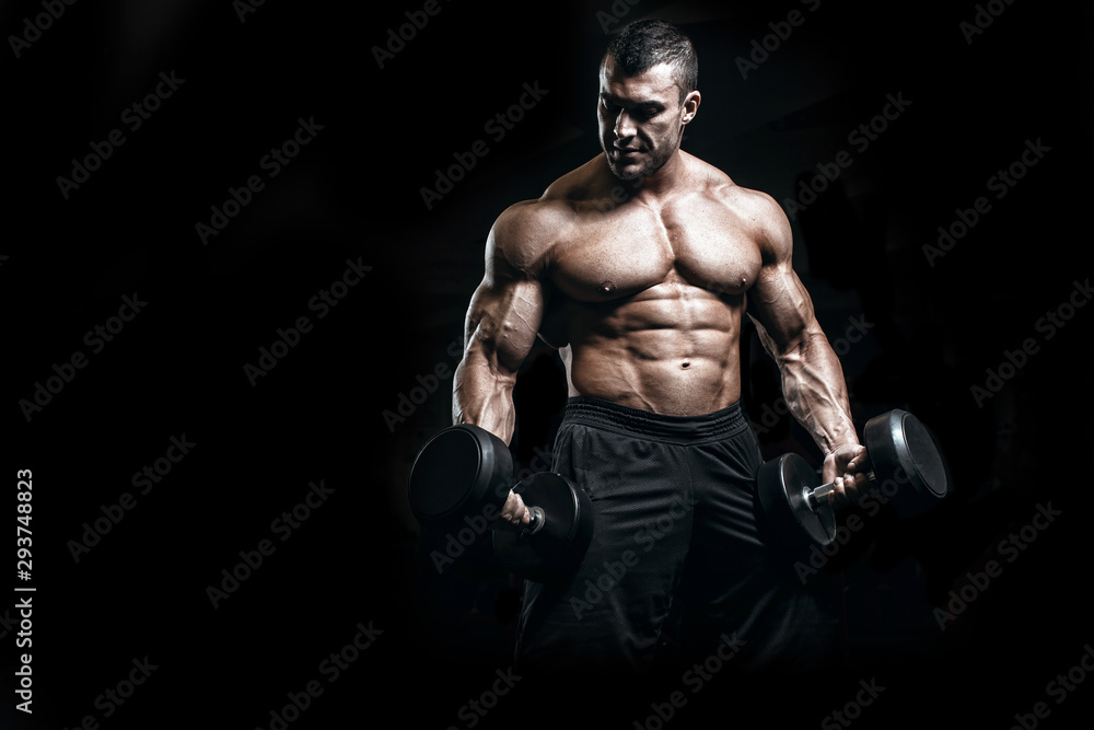 Muscular athletic bodybuilder fitness model training arms with dumbbells in gym. Concept sport photo of exercises in gym