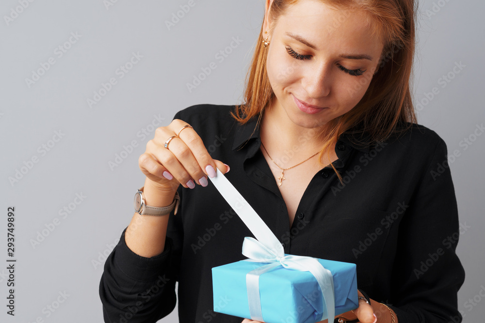 Nice woman holding a blue gift box in her hands Nice woman holding a blue gift box in her hands
