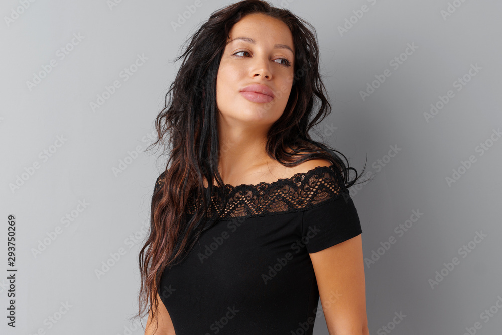 Fototapeta premium Beautiful woman brunette posing over a grey background