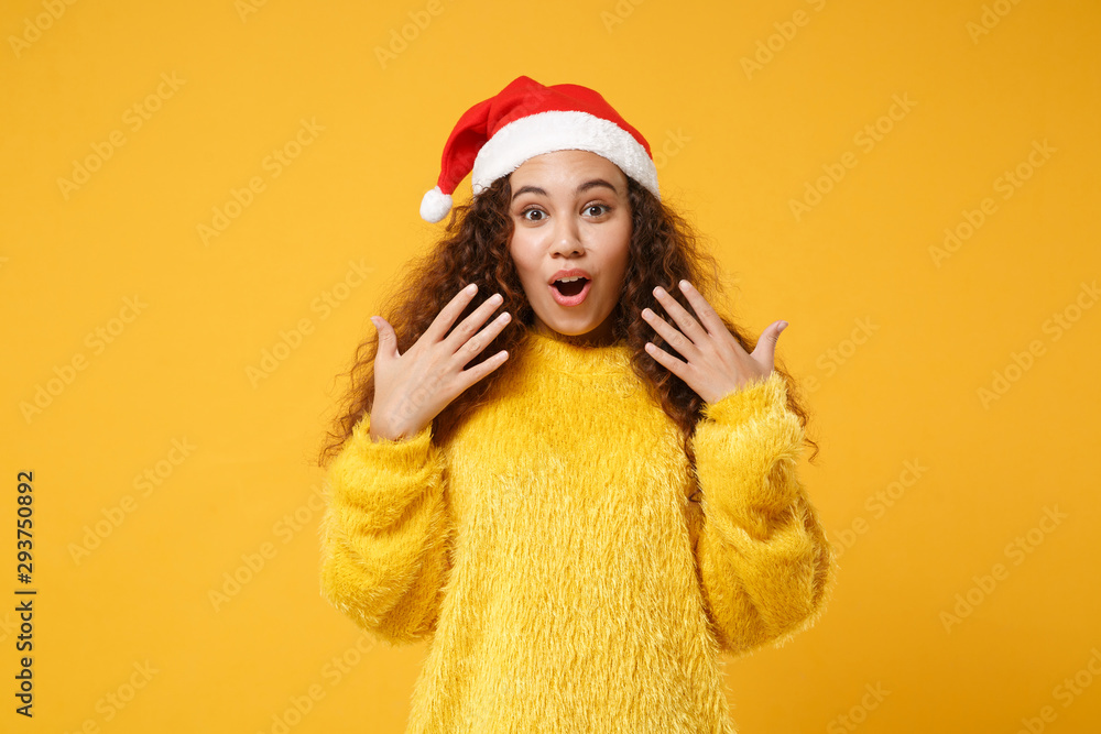 Shocked young african american Santa girl in fur sweater, Christmas hat isolated on yellow wall background. Happy New Year 2020 celebration holiday concept. Mock up copy space. Keeping mouth open. Shocked young african american Santa girl in fur sweater, Christmas hat isolated on yellow wall background. Happy New Year 2020 celebration holiday concept. Mock up copy space. Keeping mouth open.