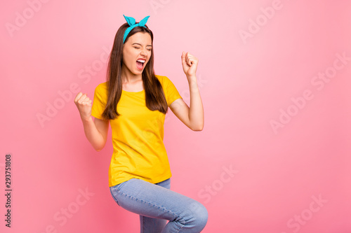 Fototapeta Naklejka Na Ścianę i Meble -  Portrait of cheerful youth raising her fists shouting yeah wearing yellow t-shirt isolated over pink background