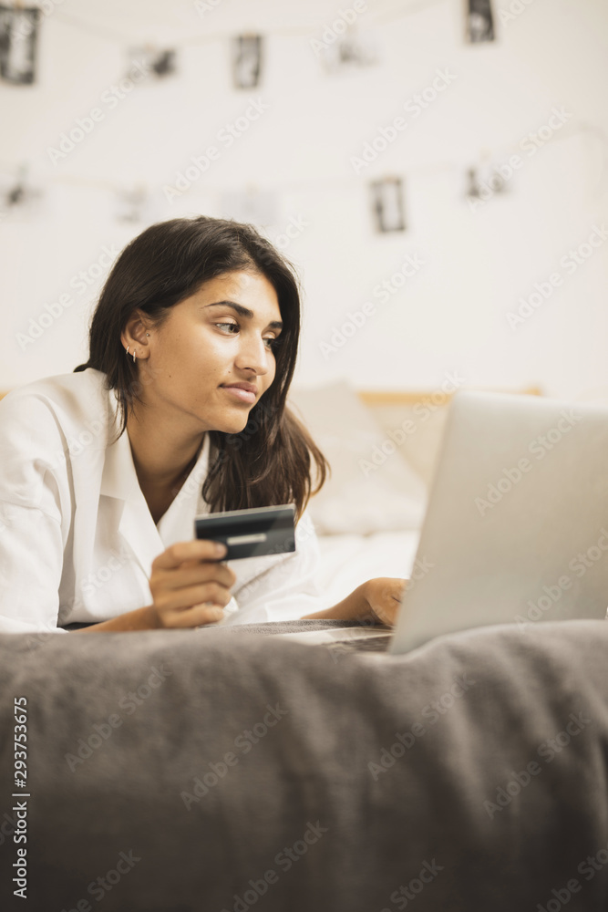 Indian woman working on a laptop and holding a card Indian woman working on a laptop and holding a card